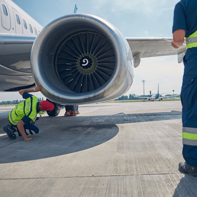 mechanics inspecting an airplane motor